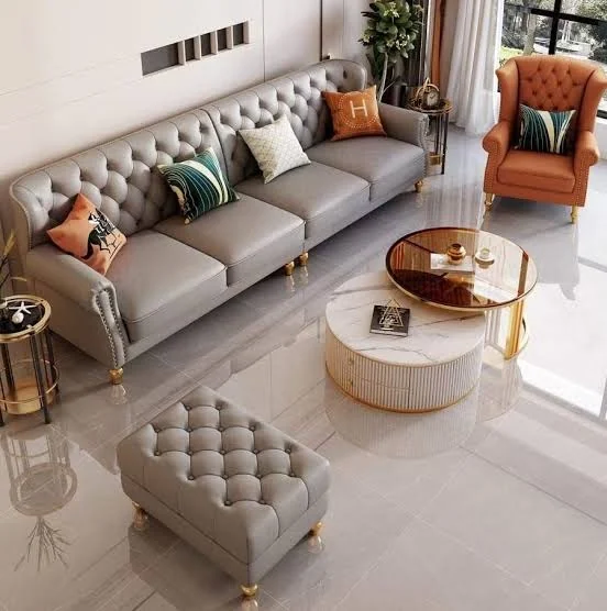 Deep-buttoned grey leather upholstery on a Chesterfield sofa.